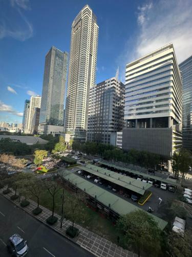 eine Skyline der Stadt mit hohen Gebäuden und einem Parkplatz in der Unterkunft Affordable Staycation Airbnb BGC in Manila
