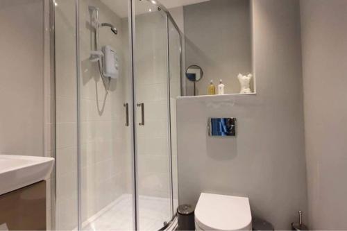 a bathroom with a shower with a toilet and a sink at Inviting 1-Bed Apartment in the heart of Sheffield in Sheffield