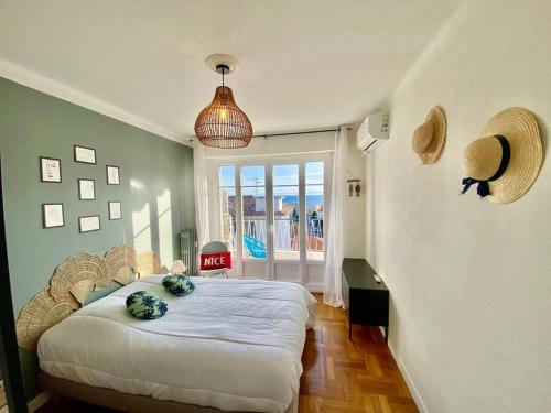 ein Schlafzimmer mit einem Bett in einem Zimmer mit einem Fenster in der Unterkunft Nice 2P Vue Mer- 5min plage, Terrasse, AC, Parking in Nizza
