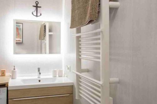 ein Badezimmer mit einem Waschbecken und einer weißen Treppe. in der Unterkunft Nice 2P Vue Mer- 5min plage, Terrasse, AC, Parking in Nizza