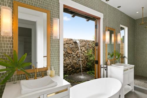 La salle de bains est pourvue d'une baignoire, d'un lavabo et d'un miroir. dans l'établissement Kukui'ula Luxury Vacation Home 62- Alekona Kauai, à Koloa