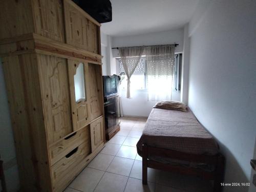 a bedroom with a large wooden cabinet and a tv at Departamento en Buenos Aires, La boca 3 amb in Buenos Aires