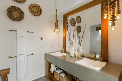 a bathroom with two sinks and a mirror at Kukui'ula Luxury Vacation Home 62- Alekona Kauai in Koloa