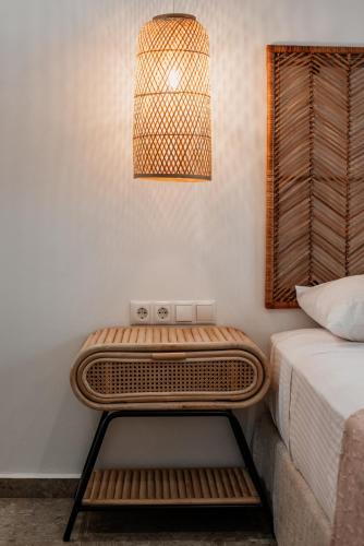 a bedside table with a lamp next to a bed at Anais Of Naxos in Agia Anna Naxos
