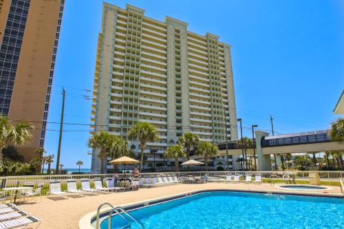 a swimming pool with a large building in the background at Celadon Beach in Panama City Beach