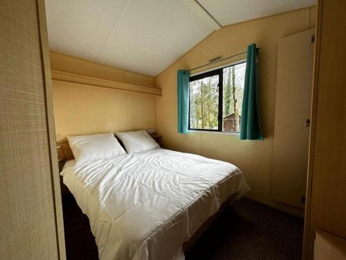 ein kleines Schlafzimmer mit einem Bett und einem Fenster in der Unterkunft Goolderheide 369 in Bocholt