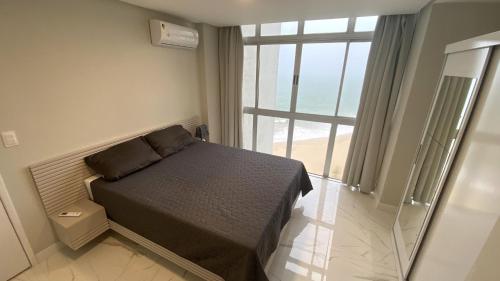 - une chambre avec un lit et une grande fenêtre dans l'établissement Boa Viagem Piedade Beach, à Récife