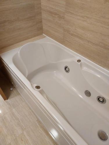 a white bath tub in a bathroom with a tile floor at Azores Essence - Paim in Ponta Delgada