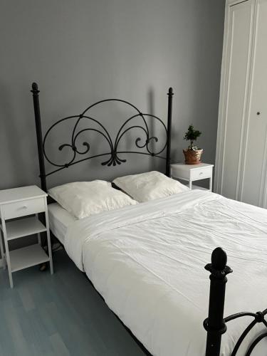 łóżko z czarną ramą oraz białą pościelą i poduszkami w obiekcie Fantastic 4 Rooms House 3km from Paris Porte de Versailles w mieście Clamart