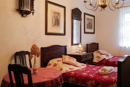 een woonkamer met 2 bedden en een tafel en een lamp bij Dworek Drawa in Drezdenko