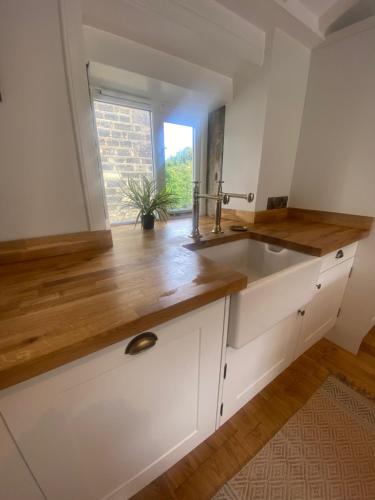 uma cozinha com um lavatório e uma janela em The Weavers Cottage em Oxenhope