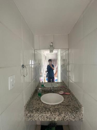 a person taking a picture of a bathroom sink at Flat com Ar Condicionado Ana Regis AP 307, Salvador in Salvador