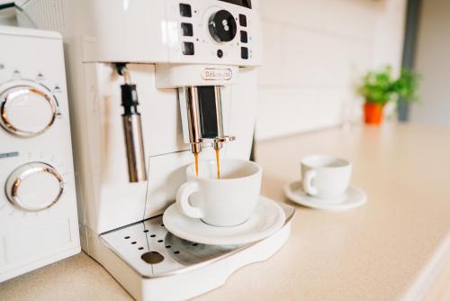 a coffee machine with two cups on a counter at KAPINA sk - Dom Jasna in Liptovský Mikuláš