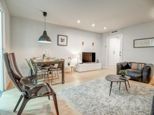een woonkamer met een tafel en een bank bij Luxe Apartment by Hello Homes Sitges in Sitges