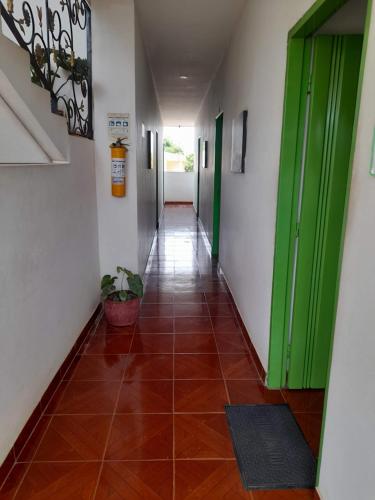 un couloir avec des portes vertes et du carrelage dans l'établissement Hotel Puertas del Norte, à Lorica