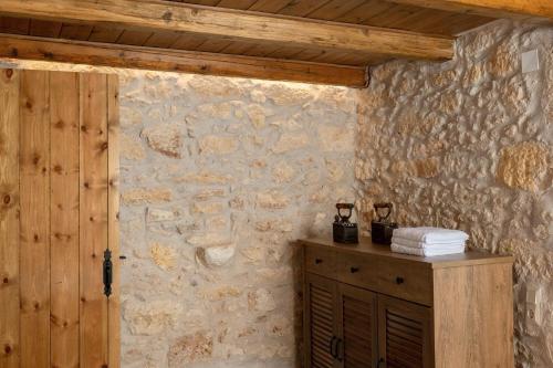 a room with a stone wall with a wooden door at Antama Living, Luxe Stonehouse with Pool & BBQ in Rethymno Town