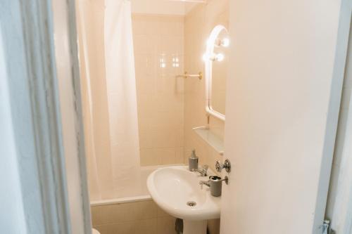 a white bathroom with a sink and a shower at Happy House in Quarteira