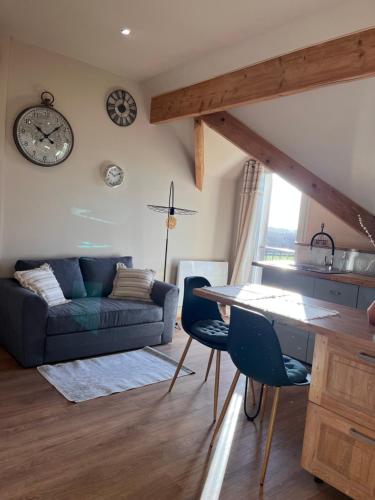 a living room with a couch and a table and chairs at Gîte de l'Orme L'Horizon in Nanteau-sur-Essonnes