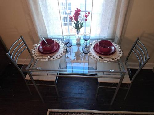 a glass table with two plates and wine glasses on it at Sunset Studio with Full Kitchen and no fee in Florence