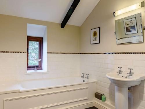 a bathroom with a bath tub and a sink at 5 Bed in Crickhowell BN365 in Llangattock