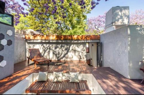 a wooden deck with a bench on a house at Siete Puertas Coyoacán in Mexico City