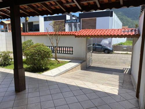 a building with a porch with a car parked in a parking lot at Casa no Centro de Peruibe in Peruíbe