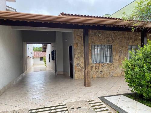 an empty courtyard of a house with a stone wall at Casa no Centro de Peruibe in Peruíbe