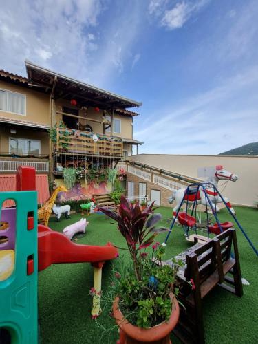 um parque infantil com um escorrega e um baloiço em Pousada Alegria do Cowboy em Penha