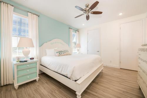 a bedroom with a white bed and a ceiling fan at Margaritaville Cottages Orlando with H2O Waterpark by Rentyl in Kissimmee