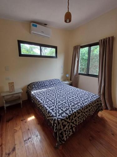 a bedroom with a bed and two windows at Reserva del Carayá in Empedrado