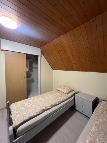 um quarto com uma cama e um tecto de madeira em Niederdorf, Baselland Hotel em Niederdorf