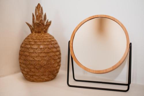 a mirror and a pineapple sitting next to a vase at Anais Of Naxos in Agia Anna Naxos