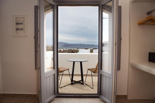 a door leading to a balcony with a table at Anais Of Naxos in Agia Anna Naxos