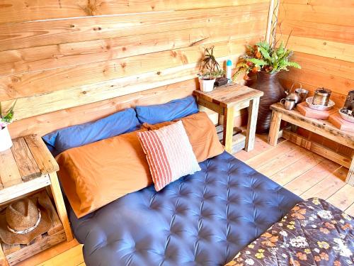 a blue couch in a room with a wooden wall at Beysicair Tents & Campground in California City