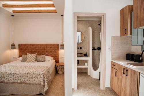 a bedroom and a bathroom with a bed and a sink at Anais Of Naxos in Agia Anna Naxos