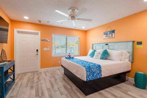 een slaapkamer met oranje muren en een bed met een plafond bij The Lofts at St Pete Beach in St Pete Beach