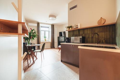 a kitchen with a counter and a dining room at Stylowy loft w kamienicy przy Dworcu PKP in Radom