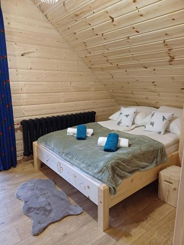 a bedroom with a bed in a wooden room at Domki po balu in Rycerka Dolna