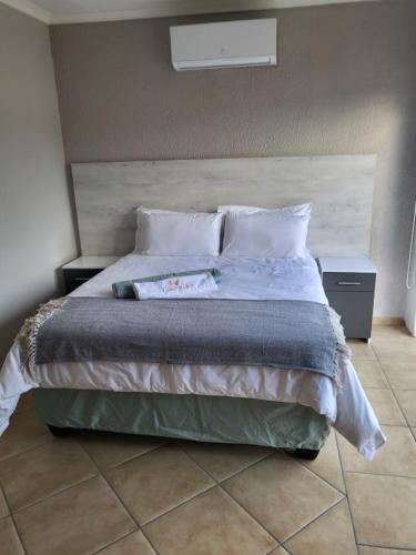 a bedroom with a large bed with two pillows at M & N Guest House in Ermelo