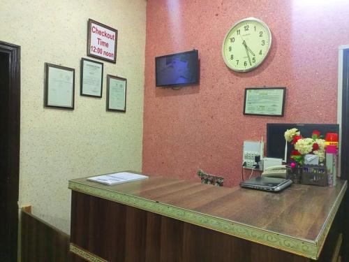 a reception desk with a clock on a wall at Furnish Rooms Near Jinnah Airport in Karachi