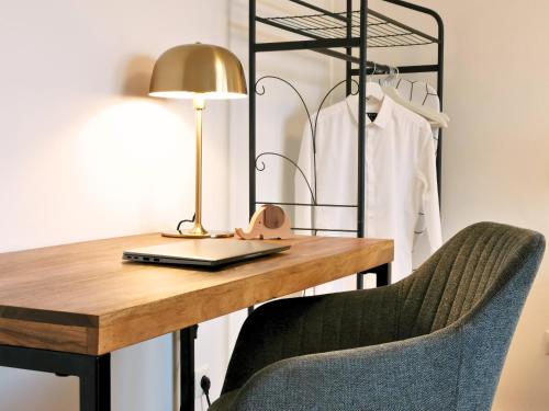 a desk with a lamp and a chair at Fynbos Deluxe, Penthouse oder Balkon, Parkplatz in Straubing