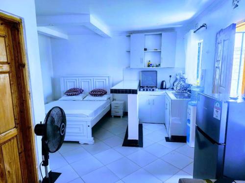 a white kitchen with a refrigerator and a sink at Swift Haven Studio Bamburi in Mombasa