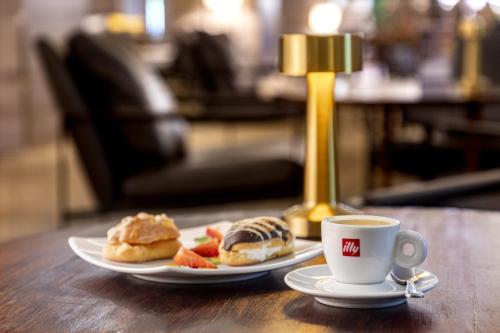 a plate of food and a cup of coffee on a table at Le Méridien Santiago by Marriott in Santiago