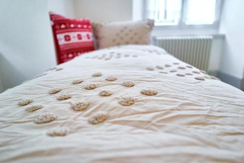 a bed with a white comforter with flowers on it at Tripple Room with Bathroom. in Därligen