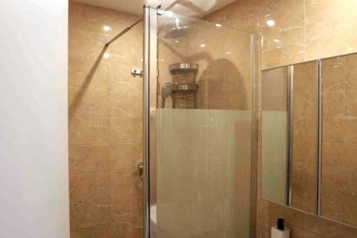een douche met een glazen deur in de badkamer bij Appartement neuf 3 ch équipé in Thiais