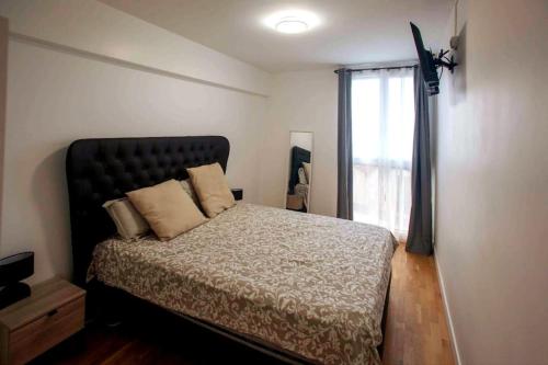 een slaapkamer met een groot bed en een raam bij Appartement neuf 3 ch équipé in Thiais