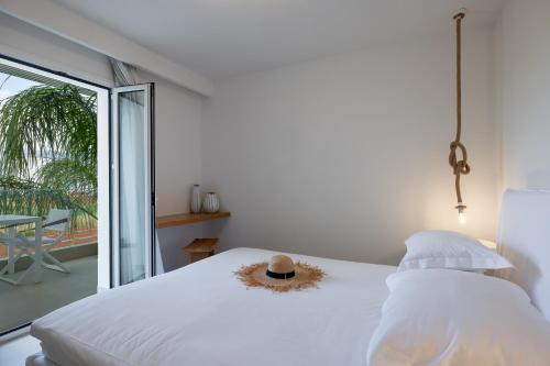 Akrogiali Garden Hotel في ماليا: غرفة نوم مع سرير مع قبعة عليه