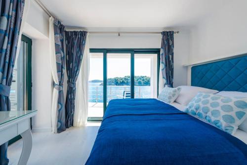 a bedroom with a blue bed and a window at Villa K Dubrovnik-5 bedroom villa with sea access in Zaton