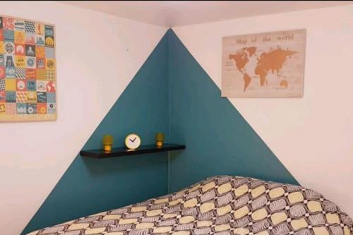 Ecke eines Zimmers mit einem Bett und einer blauen Wand in der Unterkunft Superbe T2 avec Terrasse face au parc des fontaines in Toulouse