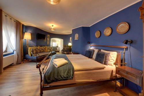een slaapkamer met blauwe muren en een bed in een kamer bij Baszta Grodzka in Jelenia Góra